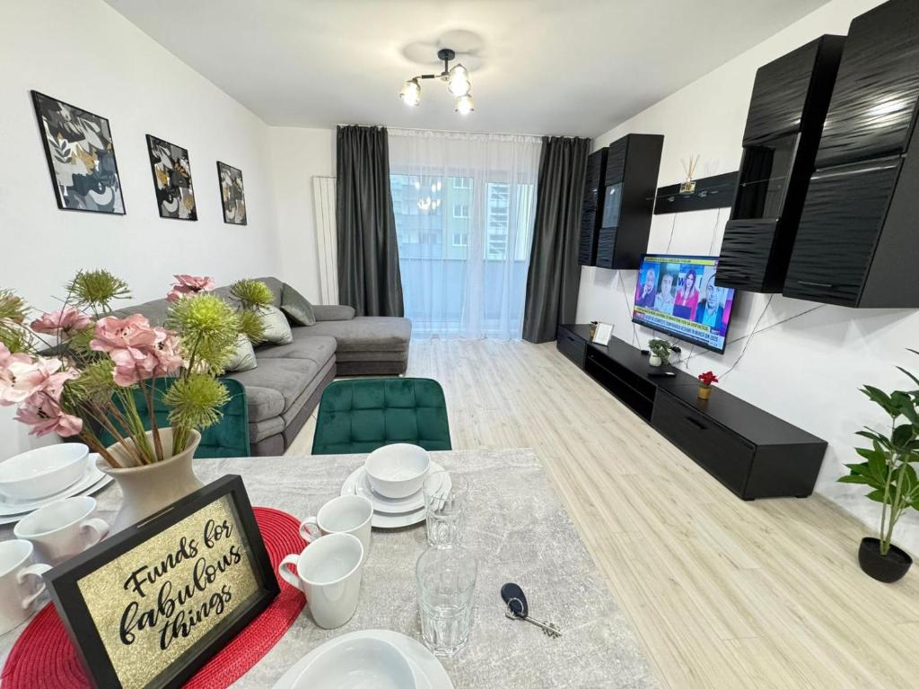 a living room with a couch and a table at Luxury Glam Apartments Coresi Mall Area in Braşov