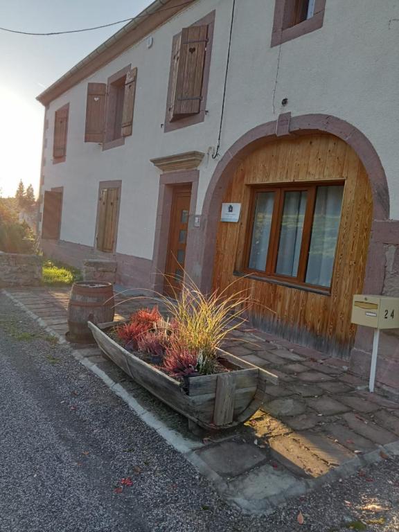 - un bâtiment avec une porte en bois et quelques plantes dans un bateau dans l'établissement Ferme des molieres avec espace détente, à Mortagne