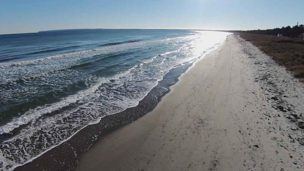 a view of a beach with the shoreline at Pension Hinter der Düne in Juliusruh