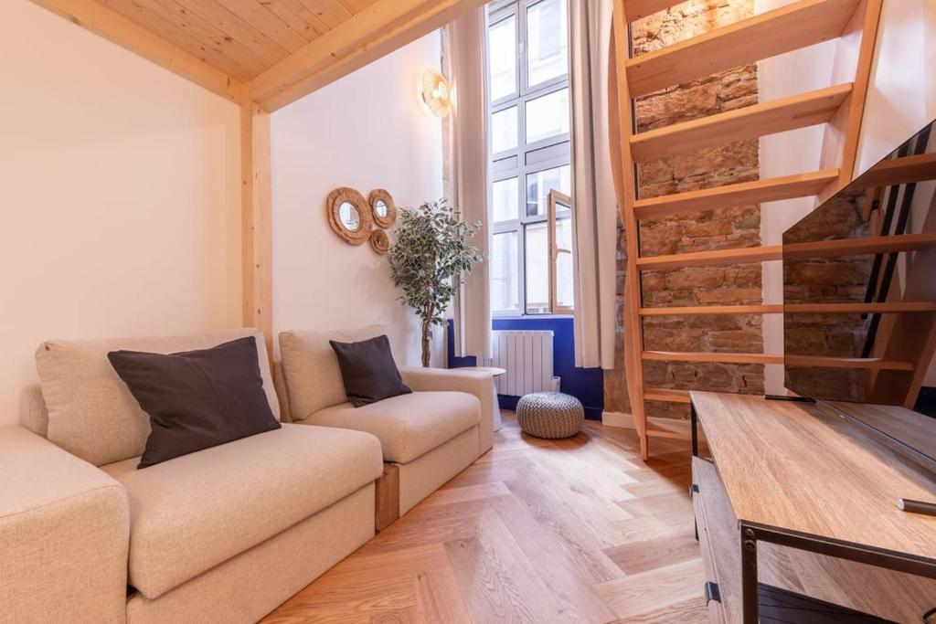 - un salon avec un canapé et du parquet dans l'établissement Le Royal - Lyon 1er - Studio Mezzanine Croix Paquet, à Lyon