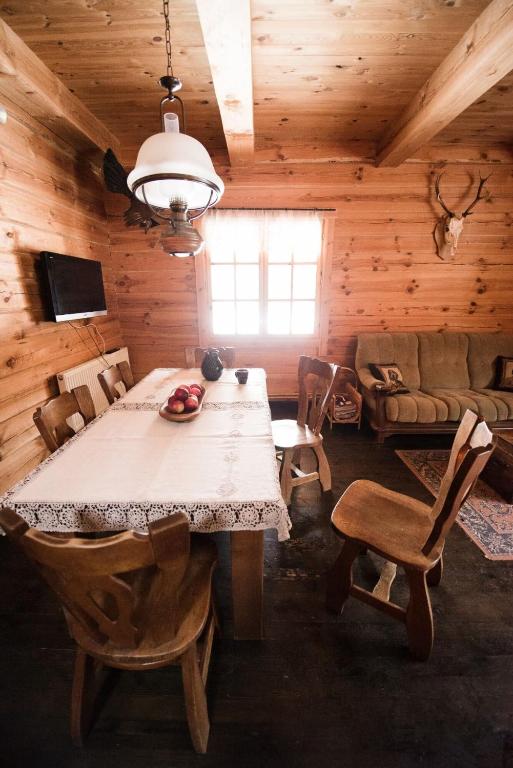 a dining room with a table and a couch at Pakaso sodyba, šiaurinė pusė in Kirdeikiai