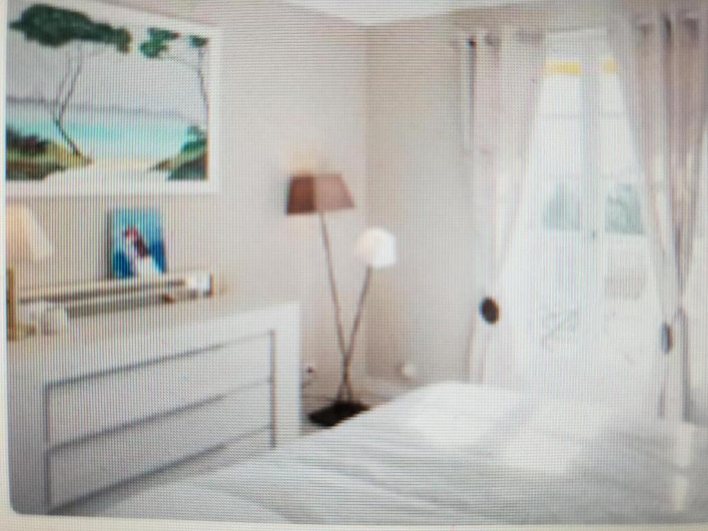 - une chambre blanche avec un lit et une lampe dans l'établissement Appartement 110 m2 vue mer environnement exceptionnel, à Hyères
