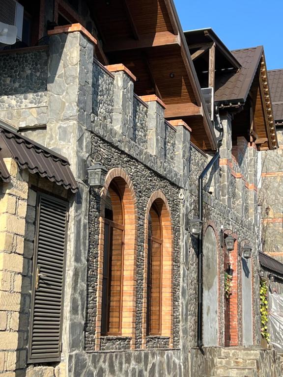 un edificio de piedra con ventanas arqueadas. en Qahramanoffshale, en Gabala