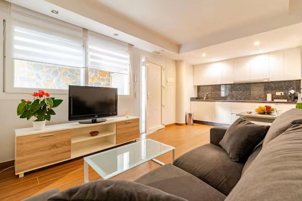 a living room with a couch and a flat screen tv at Acogedor apartamento en el centro con muchas comodidades in Marbella