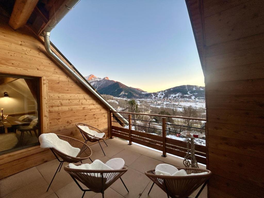a balcony with chairs and a view of the mountains at Loft Ô Faix in Ancelle