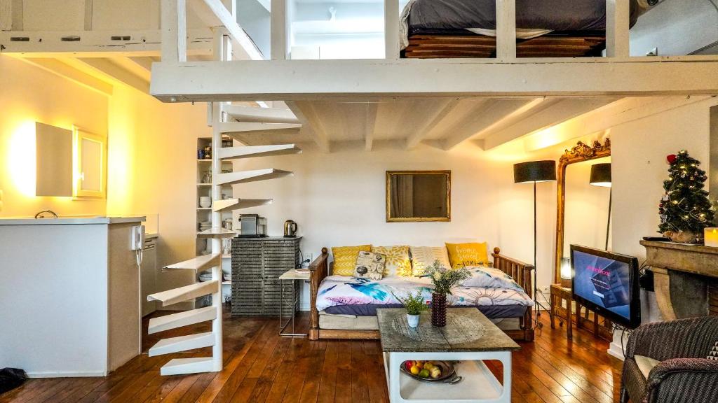 - un salon avec un lit et une mezzanine dans l'établissement 08 Grand Loft near notre dame, à Paris