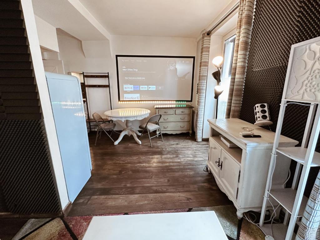 une chambre avec un écran de projection et une table dans l'établissement 05 Grand studio near Châtelet, à Paris