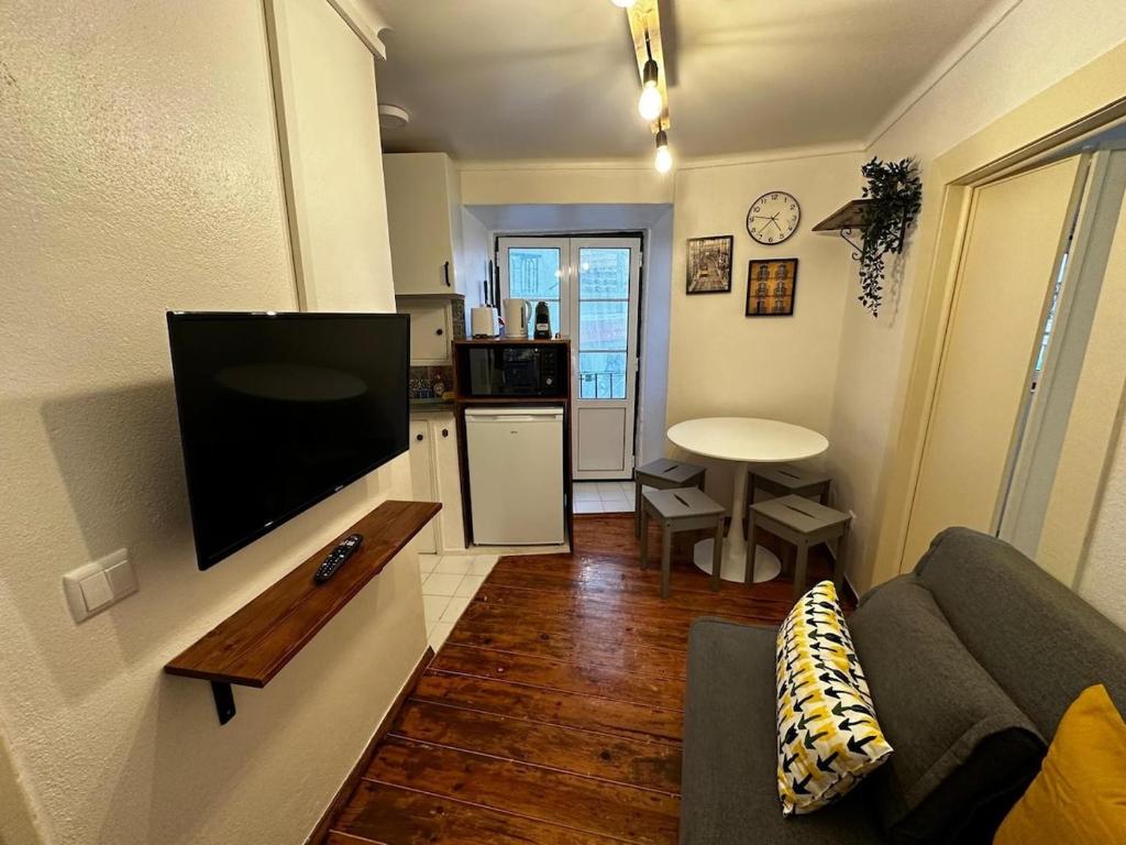 リスボンにあるCantinho das Portas do Sol IIのリビングルーム(ソファ、壁掛けテレビ付)