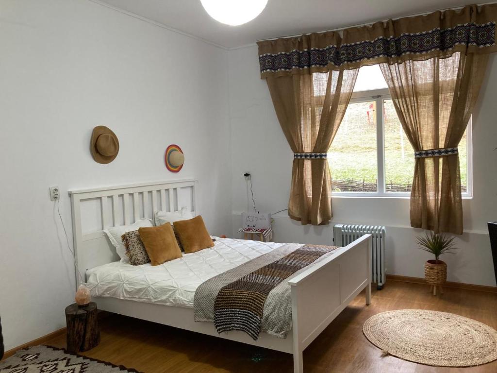 a bedroom with a white bed and a window at Agroturism Sesuri 151 in Şesuri