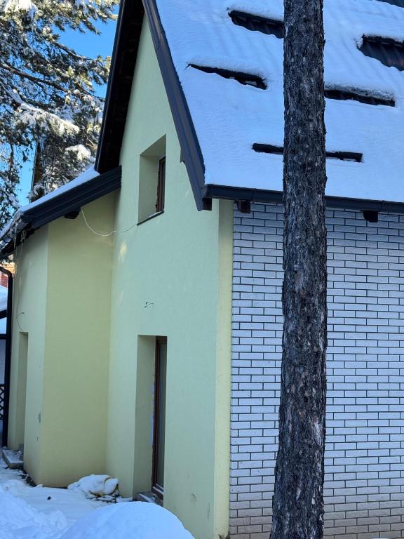 a building with snow on top of it at Apartmani Tara Vila Isidora in Bajina Bašta