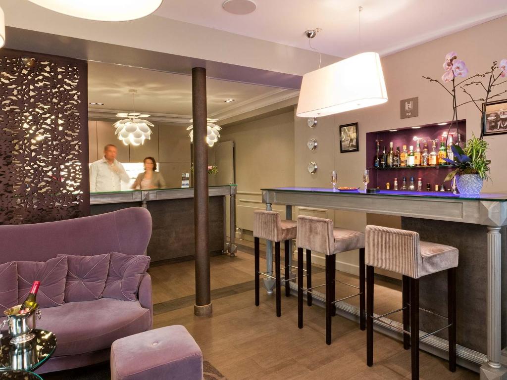 a bar in a hotel lobby with a man in the mirror at Hôtel Harvey in Paris