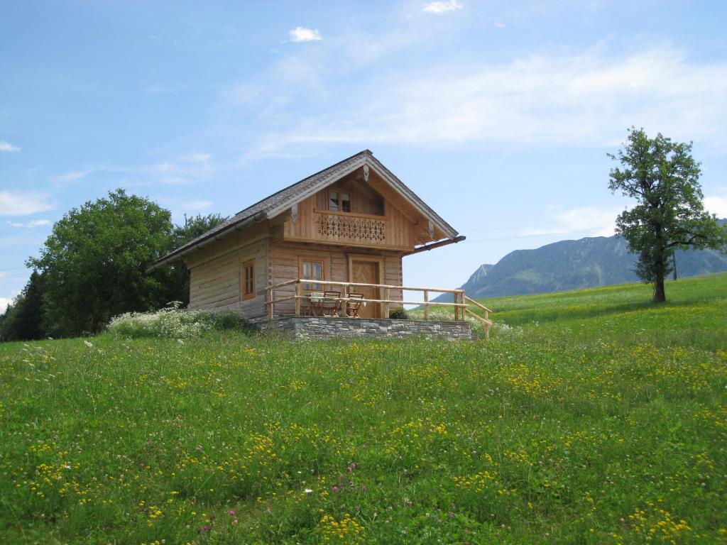 una pequeña casa de madera en un campo de hierba en Ferienhütte Wolfgangsee, en St. Wolfgang