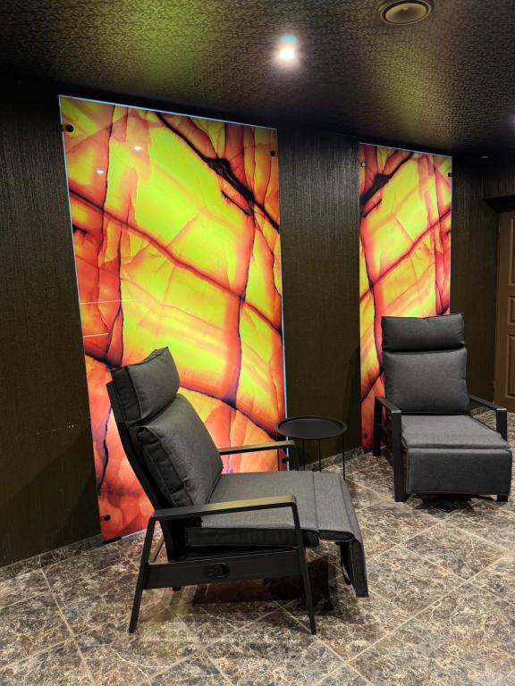 two chairs in a room with a colorful wall at Sauna Dharma Stay Self check in in Telšiai