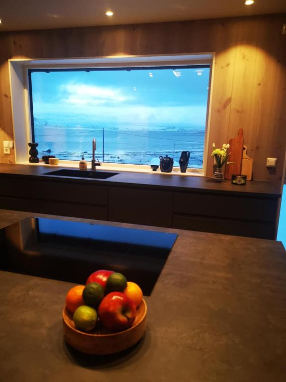 a bowl of fruit on a counter in front of a window at Lofoten Seaview apartment in Vestvågøya