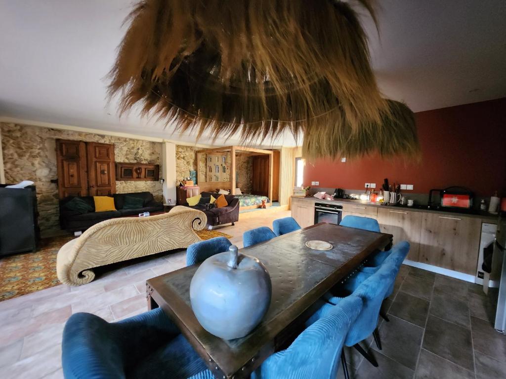 - un salon avec une table en bois et des chaises bleues dans l'établissement Le repere, à Villeneuve-lès-Béziers
