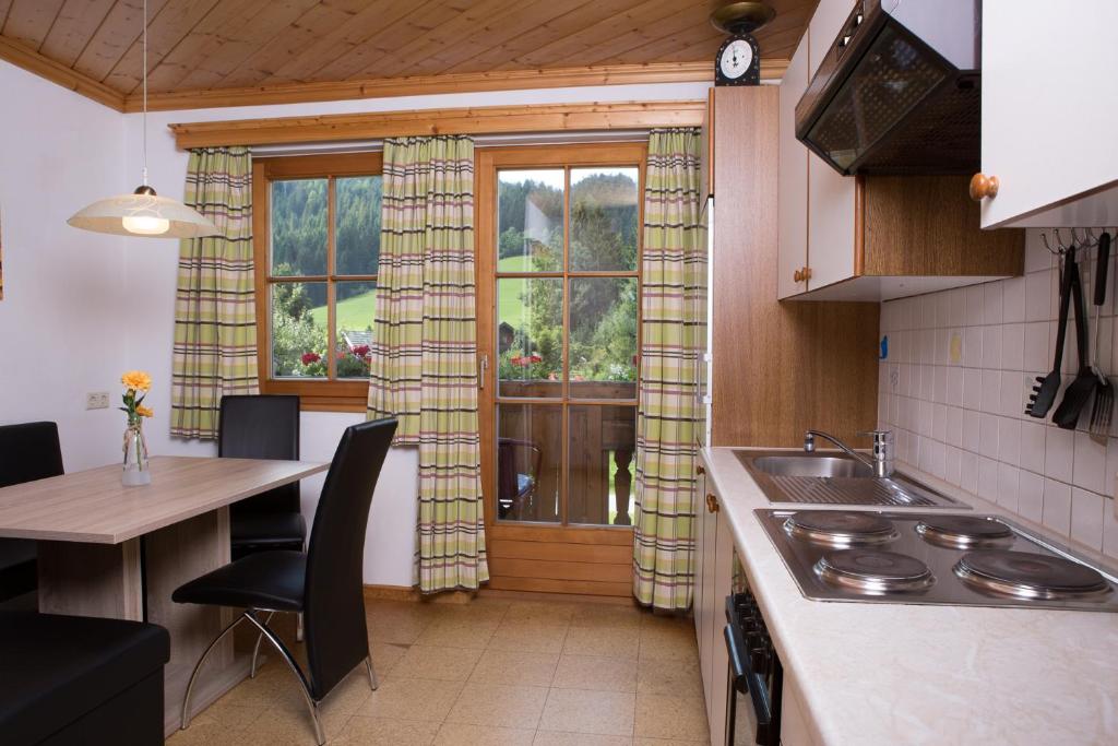 a kitchen with a sink and a table and a window at Glonerbauer Apartment in Altenmarkt im Pongau