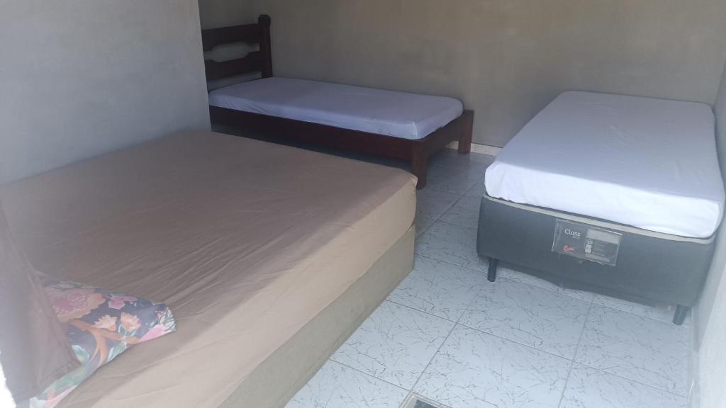 a room with two beds and a mattress and a pillow at Viver Massaguaçu Suíte 2 in Caraguatatuba