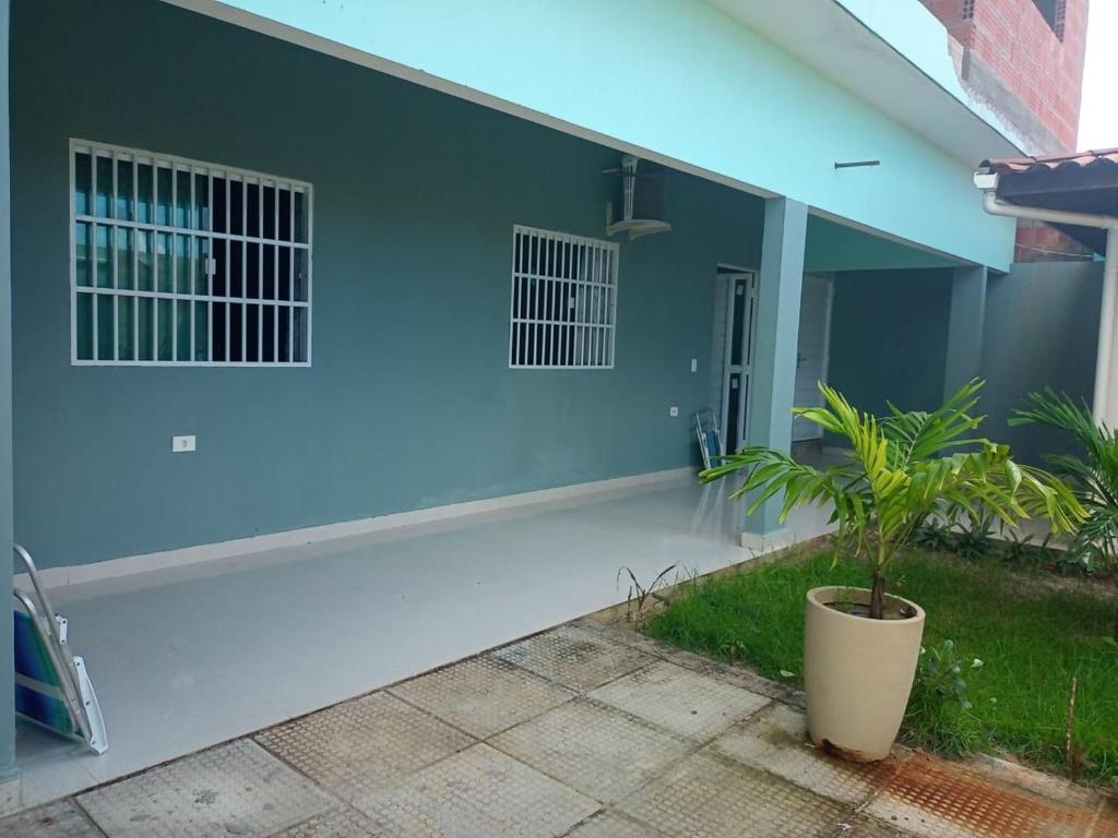 ein blaues Haus mit einer Pflanze davor in der Unterkunft Casa de praia in Tatuamunha