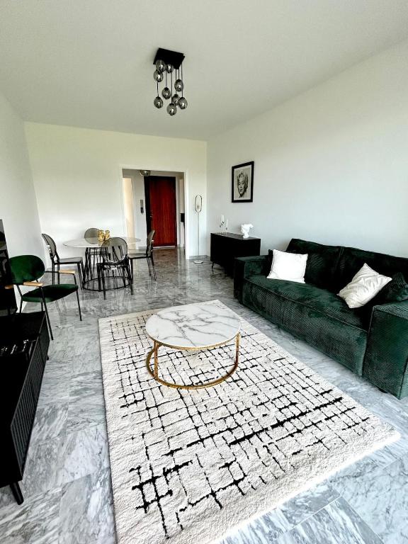 un salon avec un canapé vert et une table dans l'établissement Le Grand Soleil, à Nice