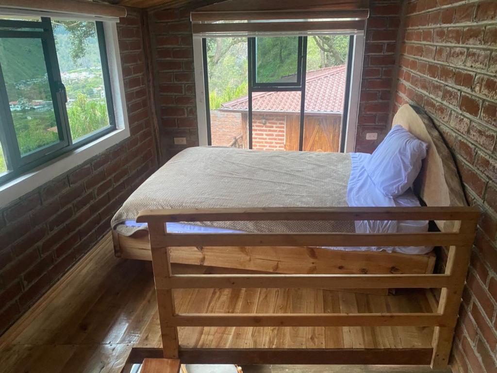 Postel nebo postele na pokoji v ubytování Cabañas El Guayabillo - Baños de agua Santa