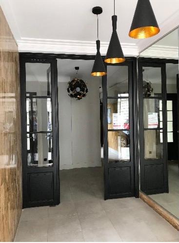 un couloir avec des portes noires dans un bâtiment dans l'établissement Appartement de charme F2, Porte St Cloud, à Boulogne-Billancourt