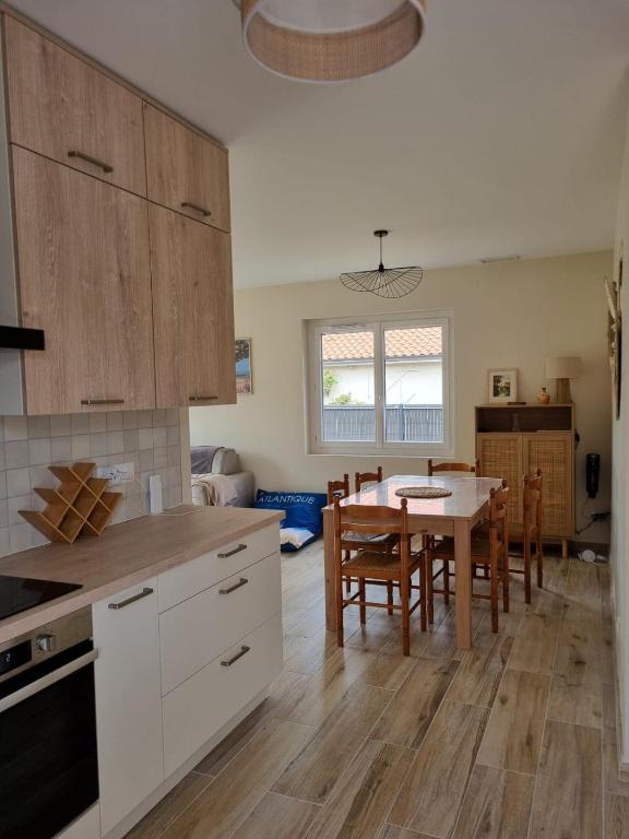 une cuisine et une salle à manger avec une table et des chaises dans l'établissement La maison du Bassin, 500 m de la plage à Andernos, à Andernos-les-Bains