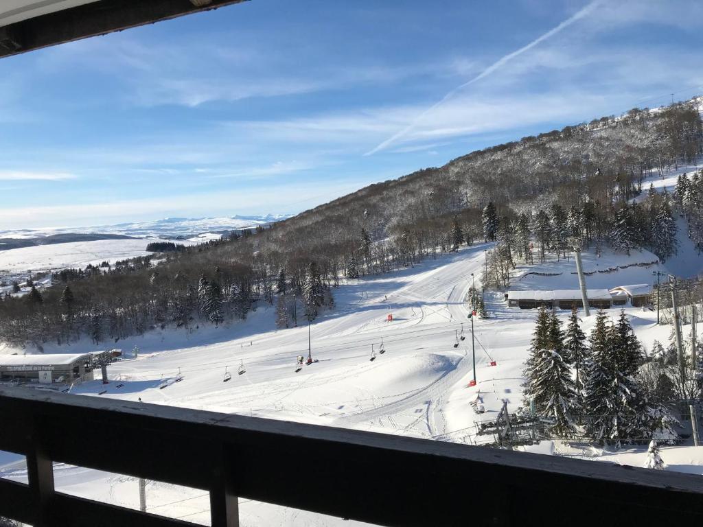 une piste de ski avec des personnes skier sur une montagne dans l'établissement Appartement au pied des pistes avec garage privé - FR-1-814-13, à Besse-et-Saint-Anastaise