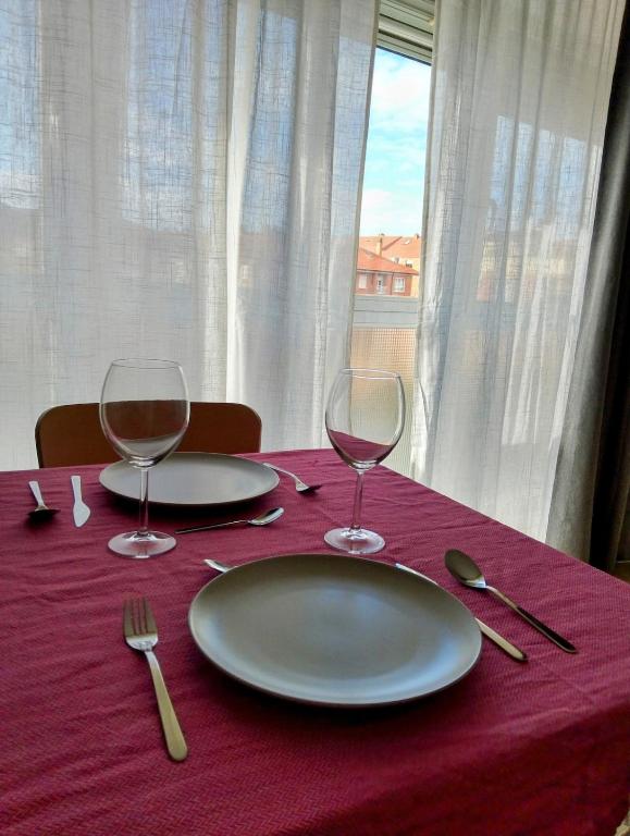 a table with two plates and wine glasses on it at La Jara in Fuenmayor
