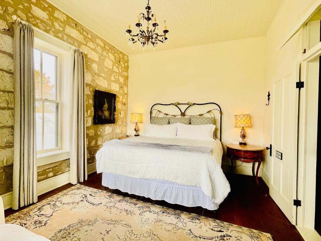 una camera da letto con un letto grande e un lampadario di Shopkeeper's Inn a Fredericksburg