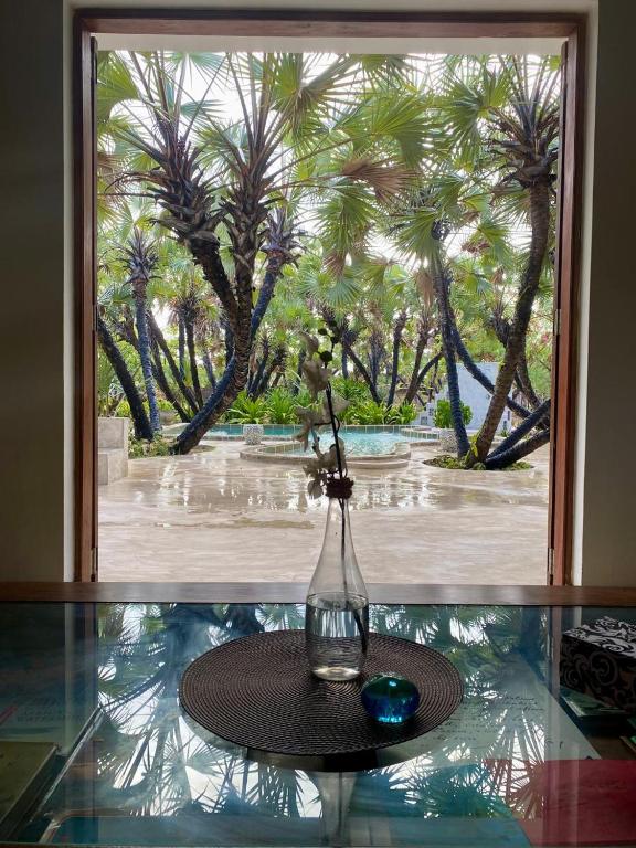 a vase with flowers on a table in front of a window at Sandy Feet Retreat in Malindi
