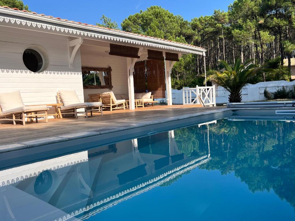 une piscine devant une maison dans l'établissement LA VILLA DES PINS, à Lacanau-Océan