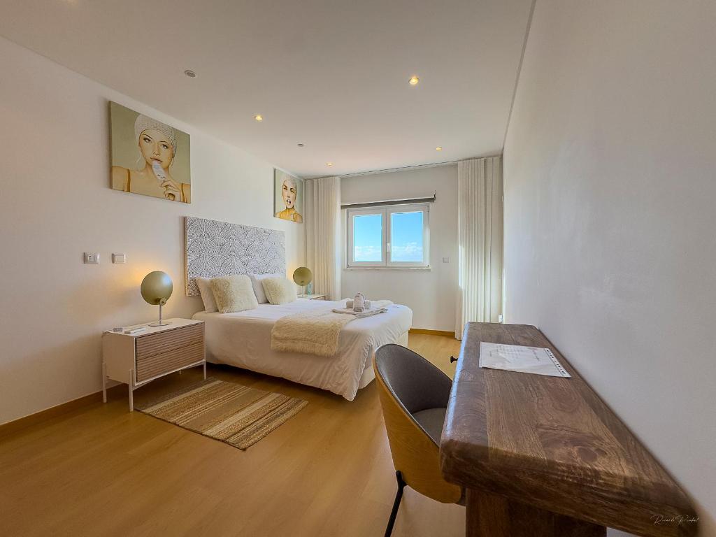 a bedroom with a bed and a table in it at Vibing & Liming Ericeira in Ericeira