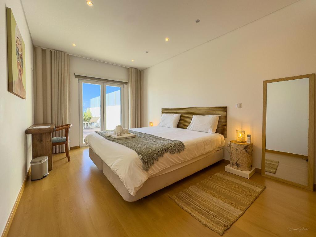 a bedroom with a large bed and a large window at Vibing & Liming Ericeira in Ericeira