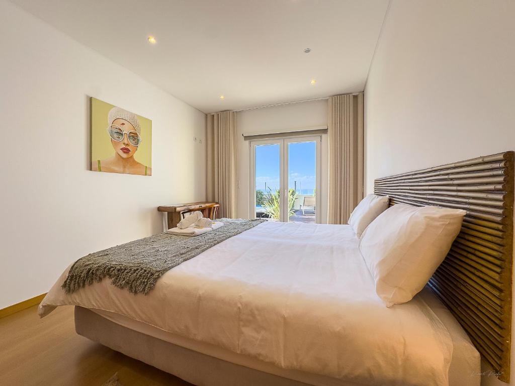 a bedroom with a large bed and a window at Vibing & Liming Ericeira in Ericeira