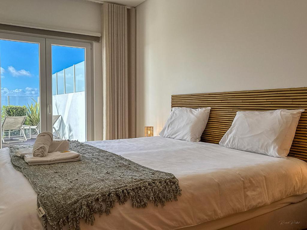 a bedroom with a large bed with a large window at Vibing & Liming Ericeira in Ericeira