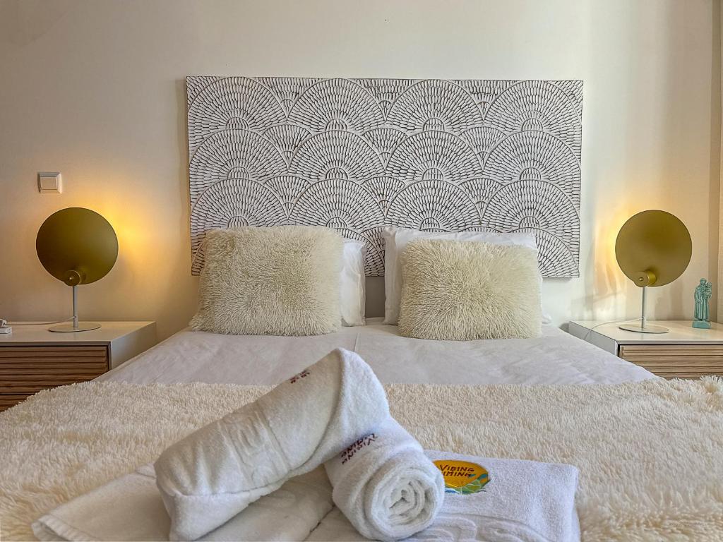 a bedroom with a bed with towels on it at Vibing & Liming Ericeira in Ericeira
