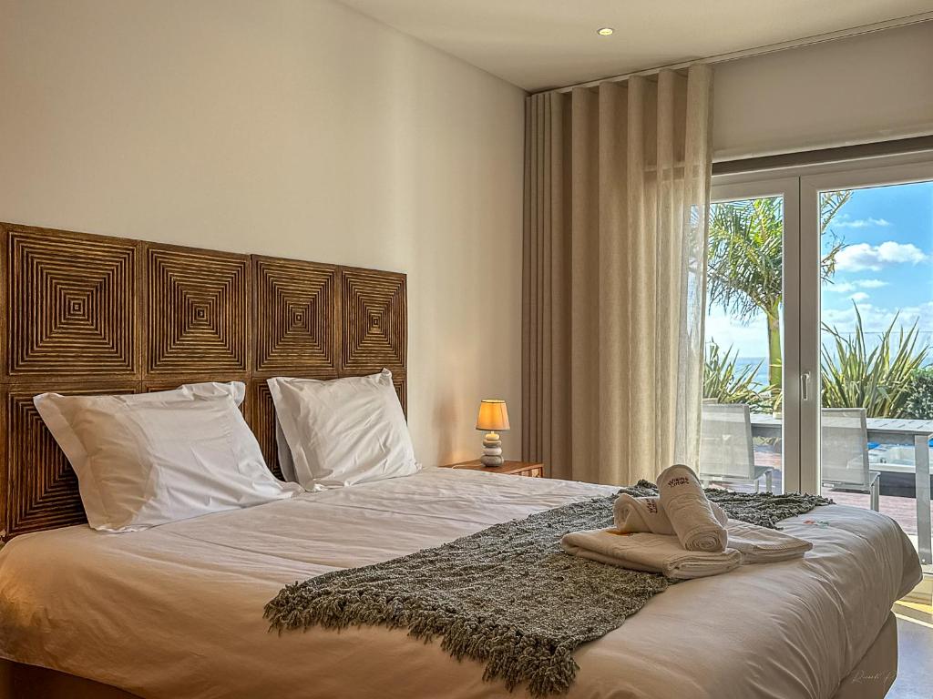 a bedroom with a bed with two pairs of shoes on it at Vibing & Liming Ericeira in Ericeira