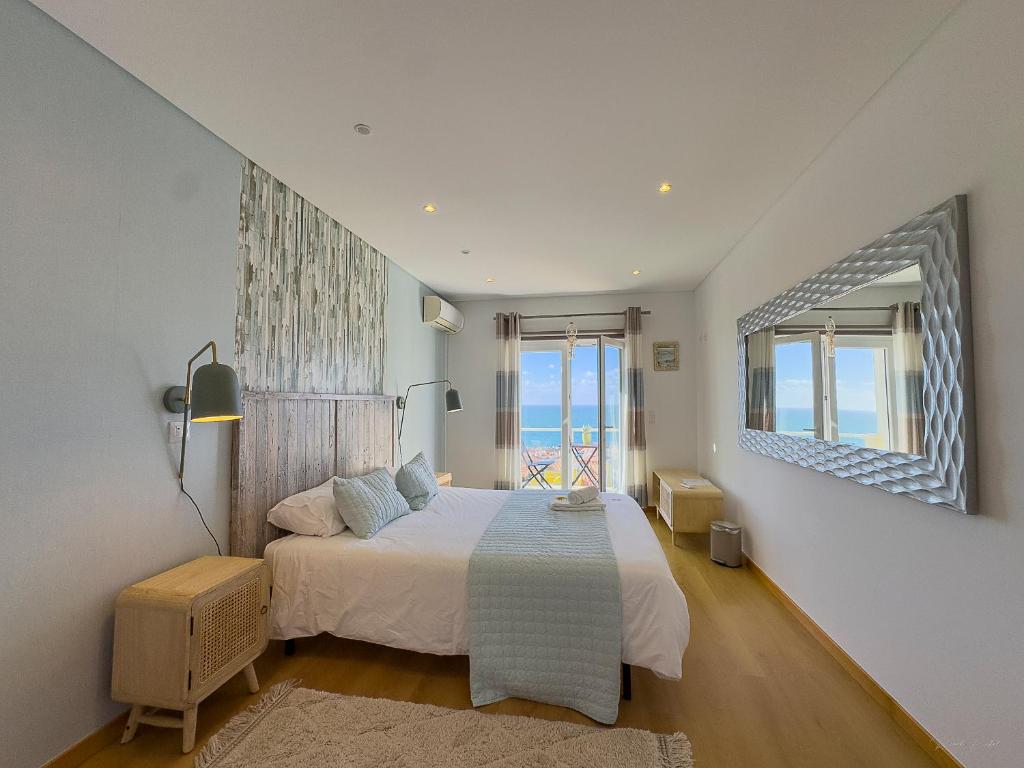 a bedroom with a bed and a large window at Vibing & Liming Ericeira in Ericeira