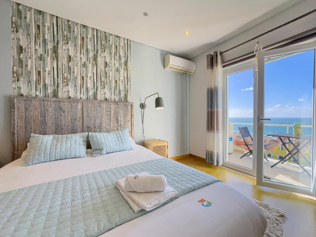 a bedroom with a bed with a view of the ocean at Vibing & Liming Ericeira in Ericeira