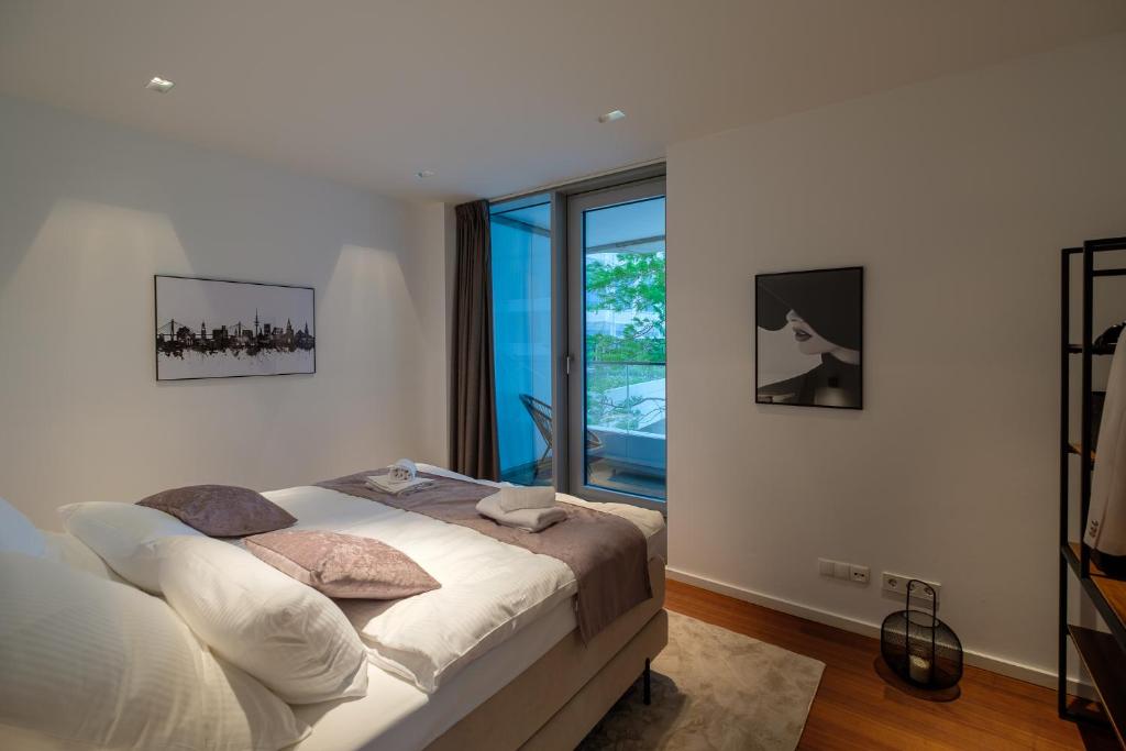 ein Schlafzimmer mit einem Bett und einem Fenster in der Unterkunft Come2Stay Hafencity - Marco Polo Tower 2 in Hamburg
