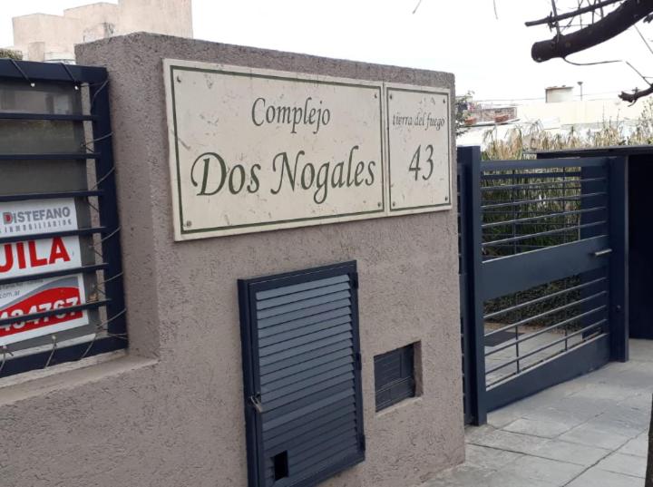 ein Schild an der Seite eines Gebäudes mit einer Tür in der Unterkunft Dos Nogales 26 in Villa Carlos Paz