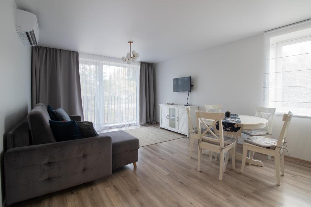 a living room with a couch and a table at Šalia bokšto in Šventoji