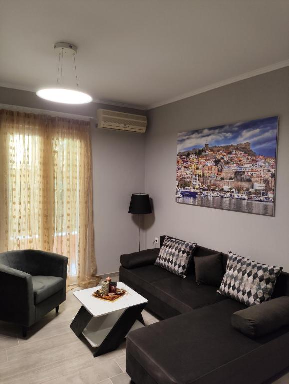 a living room with a black couch and a table at Neapolis Apartment in Kavála
