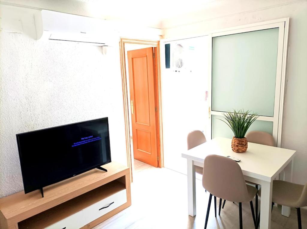 a living room with a tv and a table with chairs at El Cabanyal 400m from the Beach in Valencia