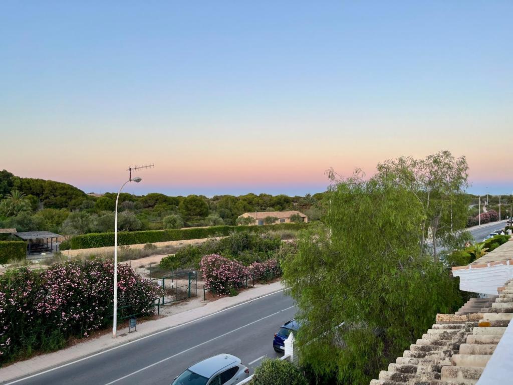 a street with cars parked on the side of a road at Townhouse med takterrass i Costa Hispania in Gran Alacant