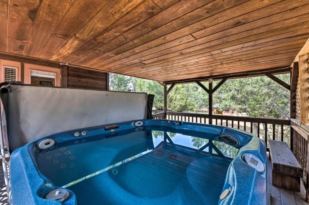 a hot tub on a deck with a wooden ceiling at Pet Friendly Retreat in Rim Country! With a Spa! in Mogollon Airpark