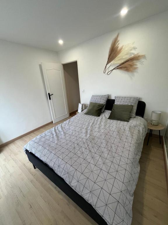 a bedroom with a bed with a feather on the wall at Zen Mayar House Toulouse centre in Toulouse