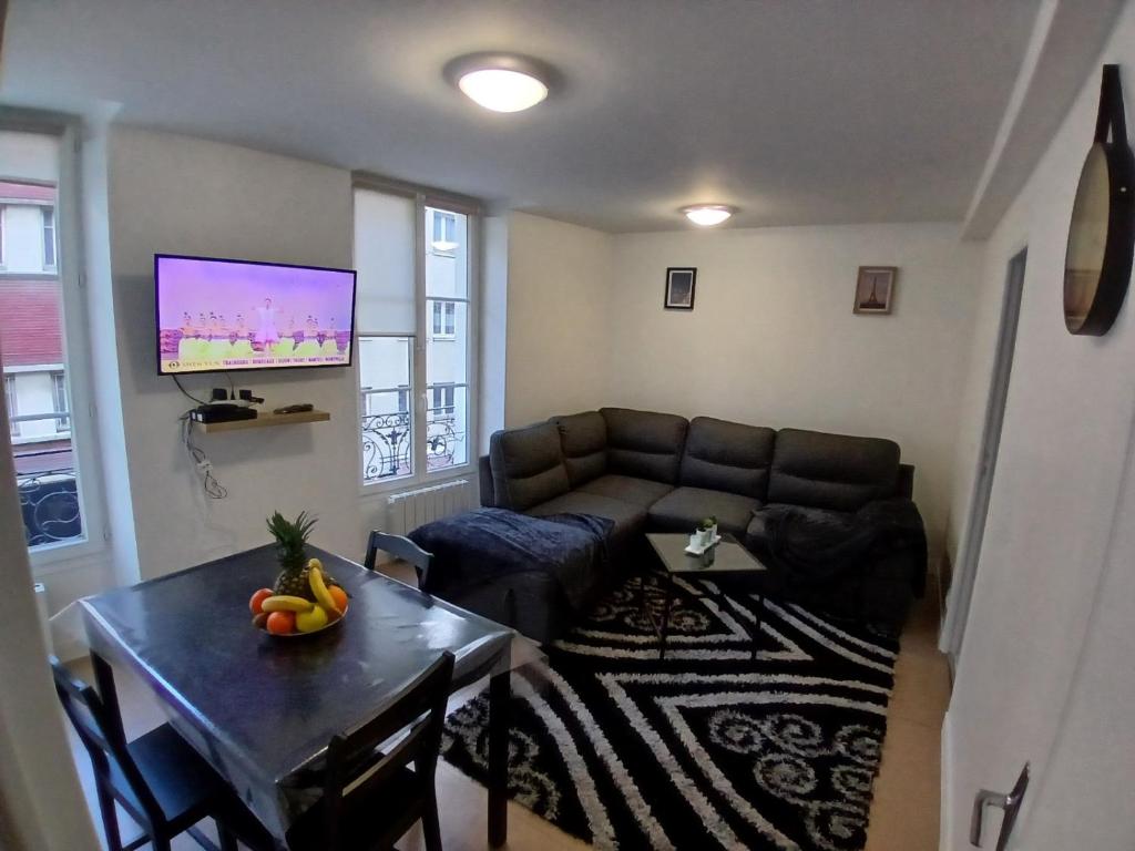 un salon avec un canapé et une table dans l'établissement Apartment near Paris by metro, à Saint-Denis