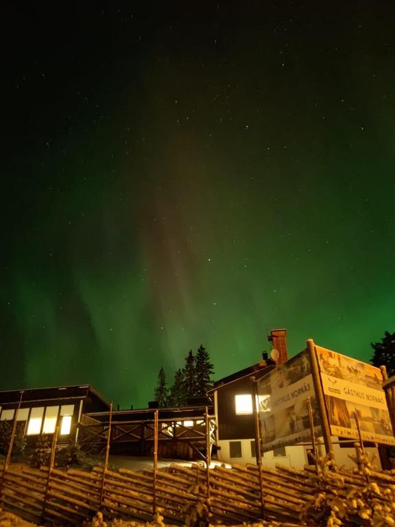 een afbeelding van een huis met een groene lucht bij Gästhus Nornäs in Nornäs