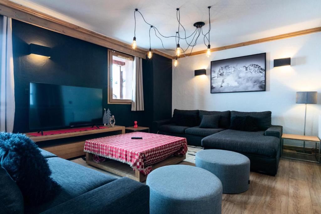 - un salon avec un canapé et une télévision à grand écran dans l'établissement Chalet Mouflon - Magnifique appartement - vue a couper le souffle MAE-1731, à Val Thorens
